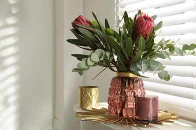 Photo of Vase with bouquet of beautiful Protea flowers on window sill indoors