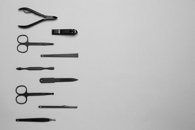 Photo of Set of manicure tools on grey background, flat lay. Space for text