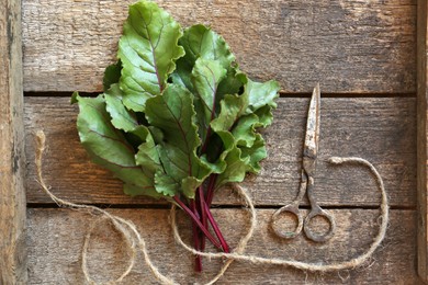 Beetroot leaves, rope and rusty scissors on wooden table, flat lay