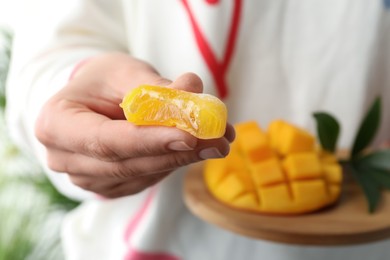 Woman holding delicious mango mochi, closeup. Japanese cuisine