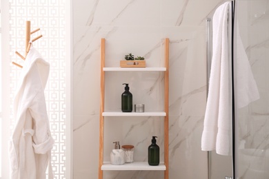 Plants and different toiletries on decorative ladder in bathroom. Interior design