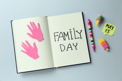 Notebook with text Family Day May, paper hand cutouts and stationery on light grey background, flat lay