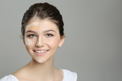 Beautiful girl on grey background. Using concealers and foundation for face contouring