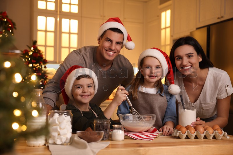 Photo of Happy family making dough for delicious Christmas cookies at home