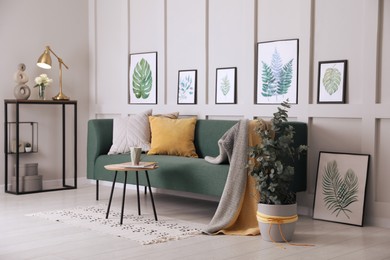 Living room with stylish furniture, beautiful eucalyptus and decorative elements. Interior design