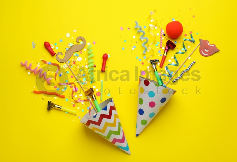 Beautiful flat lay composition with festive items on yellow background. Surprise party concept