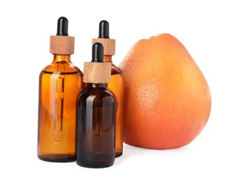 Bottles of citrus essential oil and fresh grapefruit isolated on white