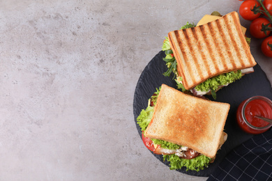 Tasty sandwiches served on grey table, flat lay. Space for text