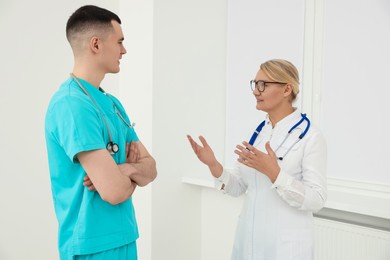 Photo of Medical doctors in uniforms having discussion indoors