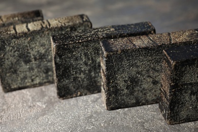 Natural tar soap on grey stone table, closeup