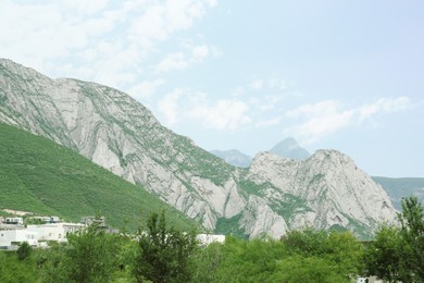 Photo of Small town near majestic mountain landscape covered with greenery