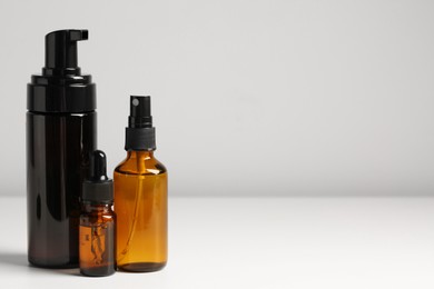 Bottles with oil on white table, space for text. Natural cosmetics