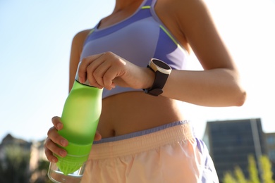 Woman with fitness tracker after training outdoors, closeup