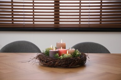 Photo of Beautiful burning candles on wooden table indoors