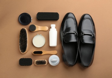 Flat lay composition with shoe care accessories and footwear on brown background