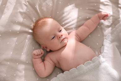 Cute little child lying in cot, above view. Healthy baby