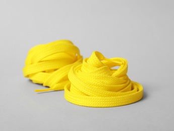 Yellow shoe laces on light grey background