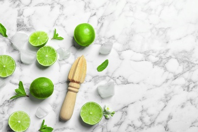 Flat lay composition with lime, mint and juicer on marble background. Refreshing beverage ingredients