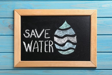 Photo of Blackboard with words Save Water and drop on turquoise wooden table, top view