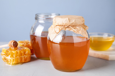 Photo of Tasty fresh honey on light grey table