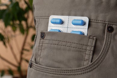 Photo of Pants with pills in pocket, closeup. Potency problem concept