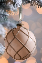 Christmas tree decorated with holiday ball against blurred lights, closeup