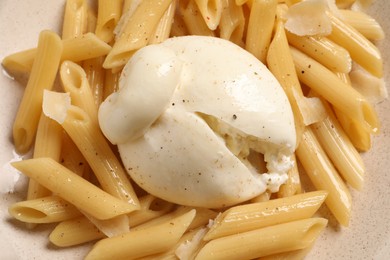 Plate of delicious pasta with burrata as background, closeup