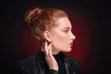 Photo of Portrait of beautiful young woman with makeup posing on color background