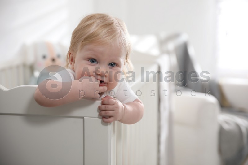Photo of Adorable little baby in crib at home