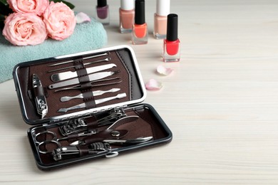 Photo of Manicure set in case on white wooden table, space for text