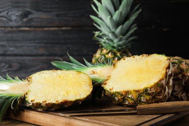 Photo of Cut fresh juicy pineapple on wooden board