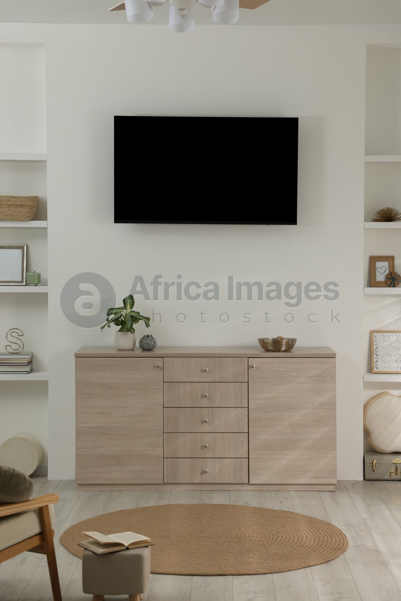 Photo of Stylish TV set mounted on wall in room