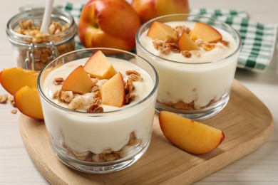 Delicious yogurt with fresh peach on granola wooden table, closeup