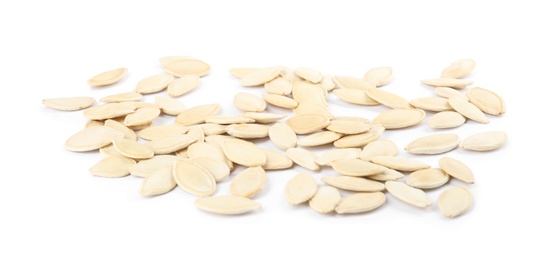 Raw unpeeled pumpkin seeds on white background