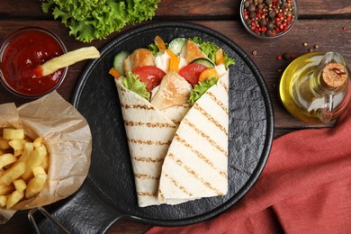 Photo of Delicious shawarma with chicken meat and vegetables  served on wooden table, flat lay