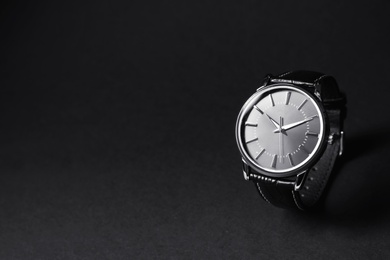 Luxury wrist watch on black background, space for text