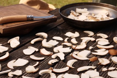 Slices of mushrooms on wooden table outdoors