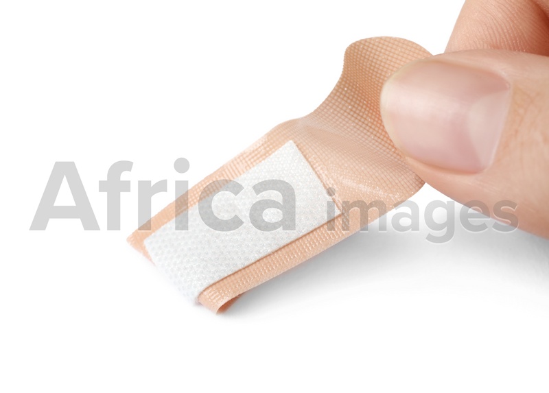 Woman putting sticking plaster on white background. First aid item