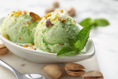 Delicious pistachio ice cream served on table, closeup