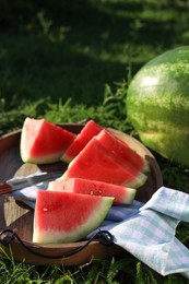 Tasty ripe watermelons on green grass outdoors