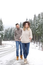 Photo of Couple walking near snowy forest. Winter vacation
