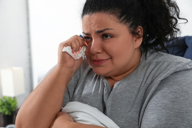 Overweight woman suffering from depression at home
