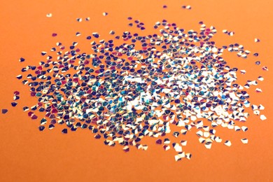 Shiny bright glitter scattered on coral background