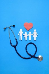 Photo of Paper family cutout, stethoscope and red heart on light blue background, flat lay. Insurance concept