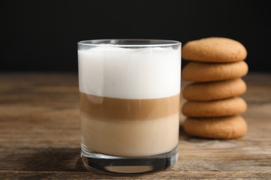 Delicious latte macchiato and cookies on wooden table
