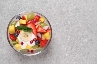Delicious fruit salad on light grey table, top view. Space for text
