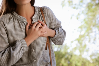 Young woman having heart attack in park, closeup