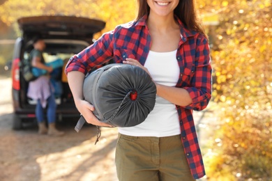 Female camper with sleeping bag outdoors, closeup