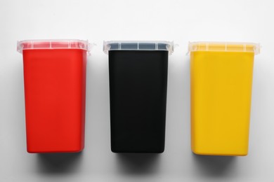 Sharps containers for used syringes on white background, top view
