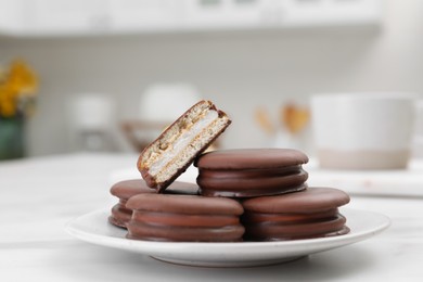 Saucer with delicious choco pies on white table in kitchen, closeup